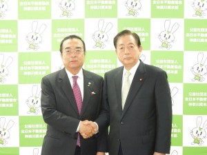 秋山本部長と握手をする太田前国交大臣